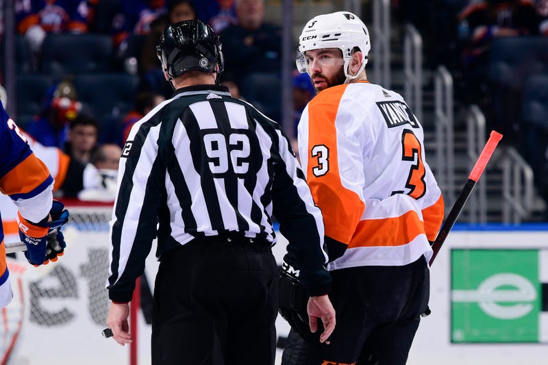 ELMONT, NEW YORK - JANUARY 25: Keith Yandle of the Philadelphia Flyers speaks with linesman Mark Shewchyk during the first period against the New York Islanders at UBS Arena on January 25, 2022 in Elmont, New York.
