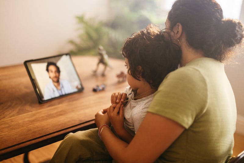 mother and child on video call with doctor