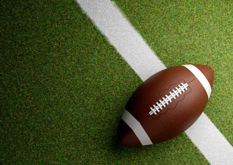 American football on stadium grass