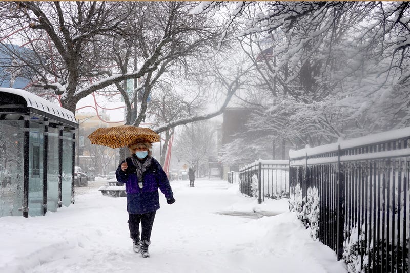 A pedestrian navigates a snow-covered sidewalk on Feb. 2, 2022, in Chicago.