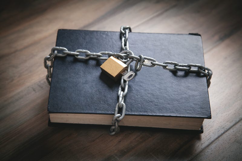 A restricted book with chains and a lock on it. 