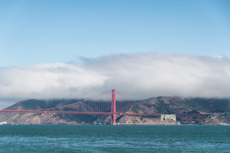 The Golden Gate Bridge on San Francisco Bay under a cloud of fog with the Marin Headlands in the background.