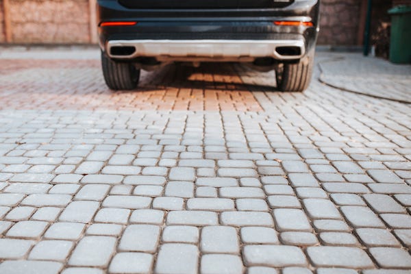 Car parked on cobblestone driveway