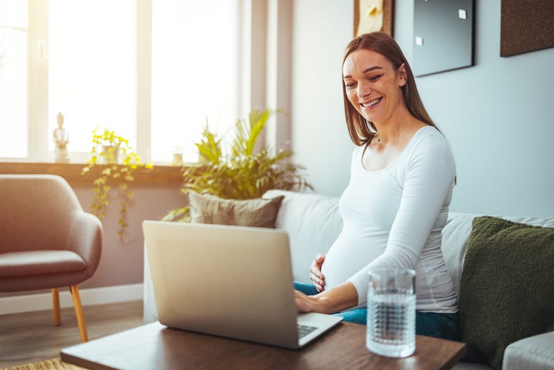 Pregnant woman working from home. 