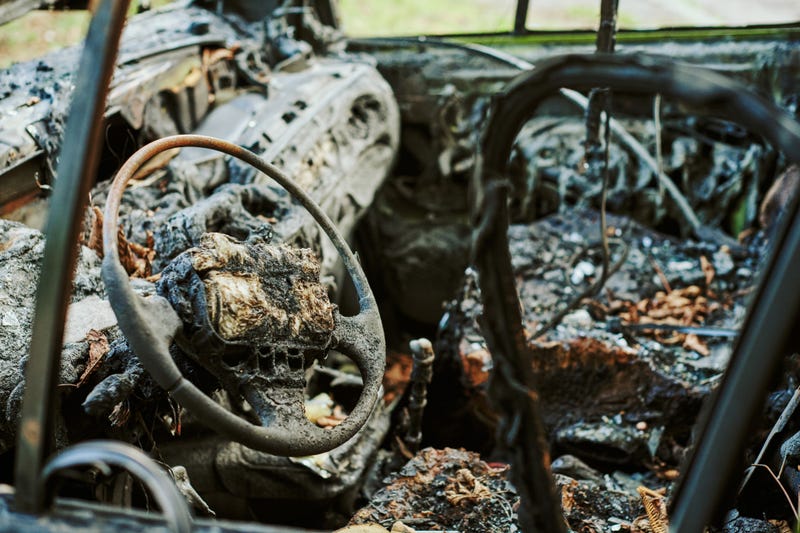 Burned car interior, close up vehicle fire, fires out. Burned automobile, car fire, vehicle fire due to short circuit, arson, smoke. Fire damaged motor vehicle