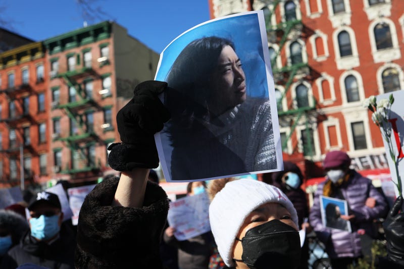 A person holds a photo of Christina Yuna Lee as people gather for a rally protesting violence against Asian Americans at Sara D. Roosevelt Park in Chinatown on Feb. 14, 2022