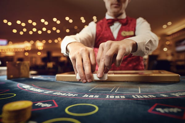 Dealer shuffling a deck of cards at a poker table in a casino