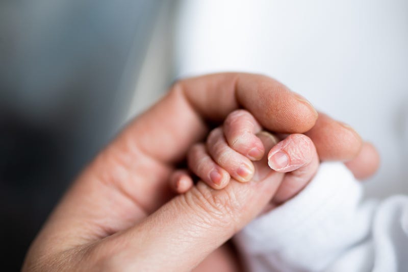 Newborn holding mother's hand