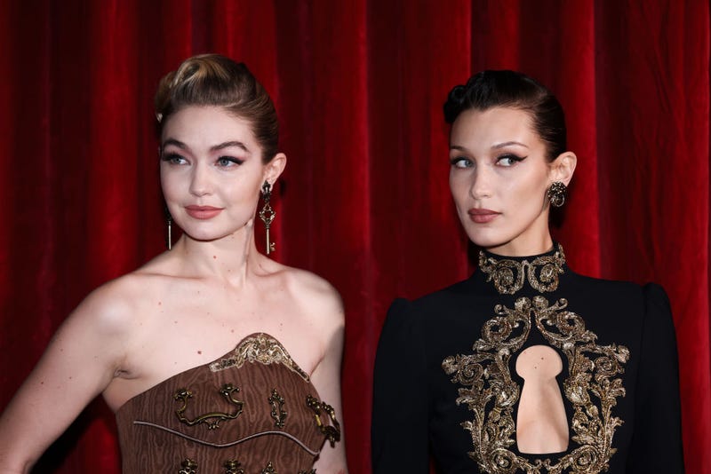 Gigi Hadid and Bella Hadid pose backstage of the Moschino fashion show during Milan Fashion Week on Feb. 24, 2022.