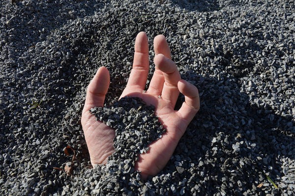 Hand emerging from being buried in the dirt