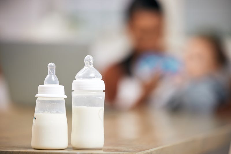 Defocused shot of a mother feeding her baby at home.