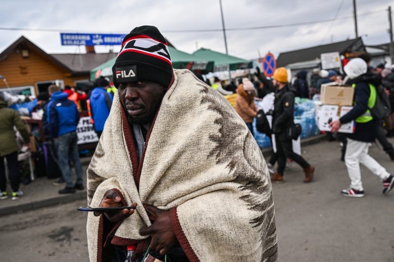 Man from African nations wrapped in blankets walk as they look for a mean of transport to reach the next city at the Polish Ukrainian border crossing on February 28, 2022 in Medyka, Poland. More than 500, 000 people have crossed to bordering countries from Ukraine in the first five days of the Russian invasion.