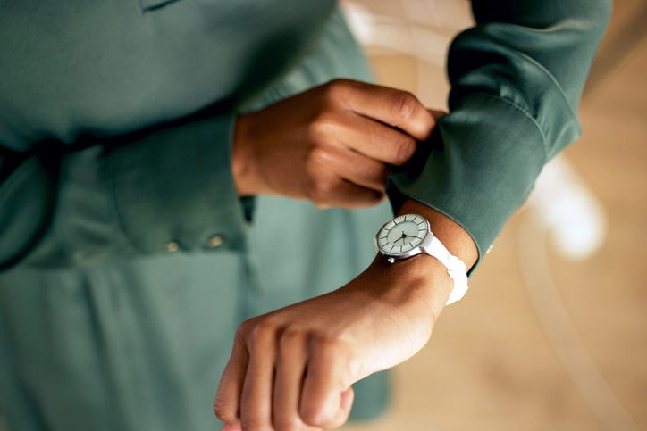 Person checking their watch to see if they are late?