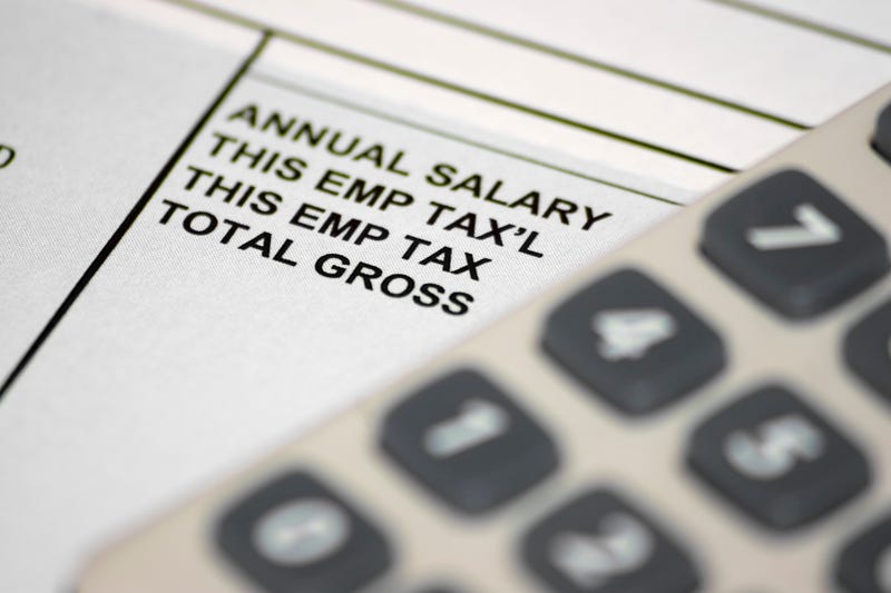 A pay slip underneath an out of focus calculator 
