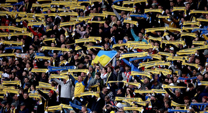 Southampton fans hold banners and scarves with the Ukrainian flag to indicate peace and sympathy with Ukraine prior to the Premier League match between Aston Villa and Southampton at Villa Park on March 05, 2022 in Birmingham, England.