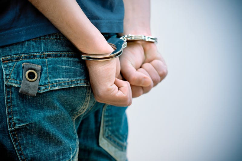 Young man in handcuffs.
