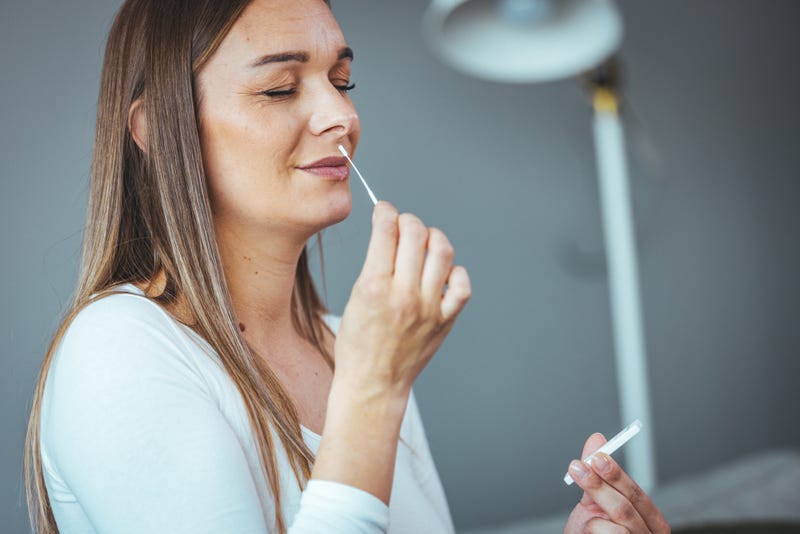 Woman using at-home COVID test stock photo. 