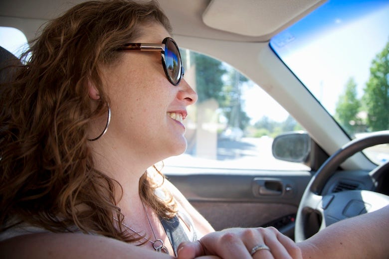 Smiling woman driving car