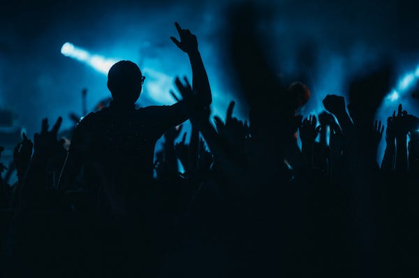 Silhouette of man in front of a crowd at a concert