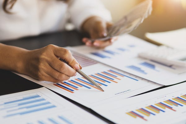 Woman holding cash and looking at accounting report
