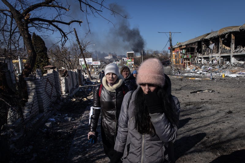 People walk amid destruction as they evacuate from a contested frontline area between Bucha and Irpin on March 10, 2022 in Irpin, Ukraine. Irpin, a suburb northwest of Kyiv, has experienced days of sustained shelling by Russian forces advancing toward the capital
