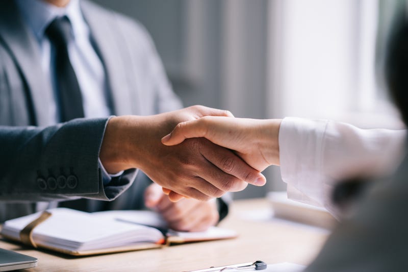 Prospective employee shakes hands with potential employer at a job interview. 