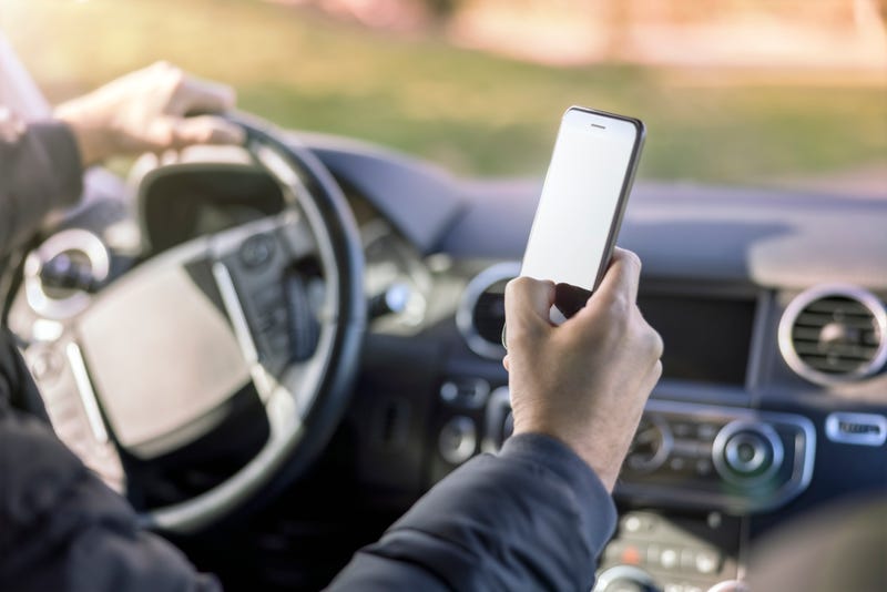 Person holding phone while driving