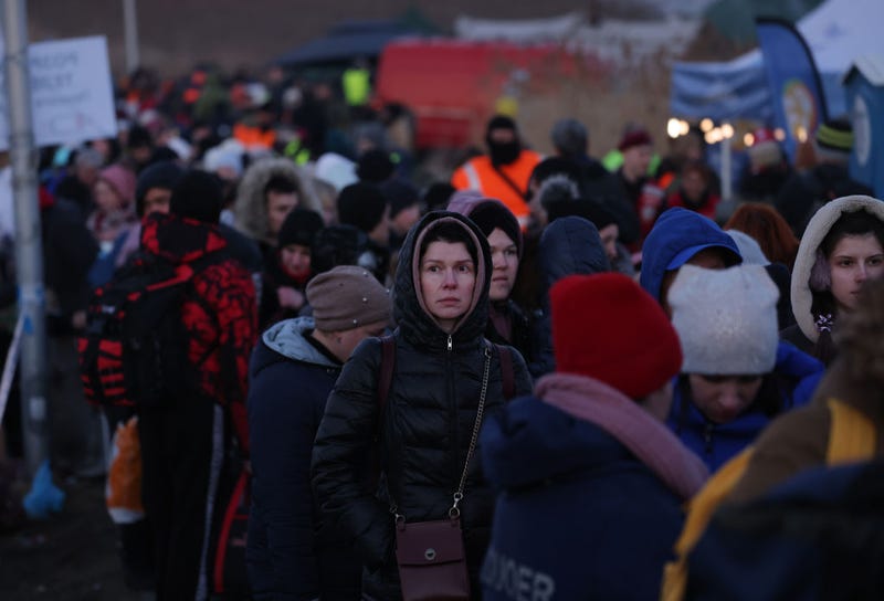 FILE - People who have just crossed from war-torn Ukraine into Poland wait to board buses provided by Polish authorities at the Medyka border crossing on March 11, 2022 in Medyka, Poland. Approximately one and a half million people have arrived in Poland from Ukraine since the Russian invasion of Feb. 24.  