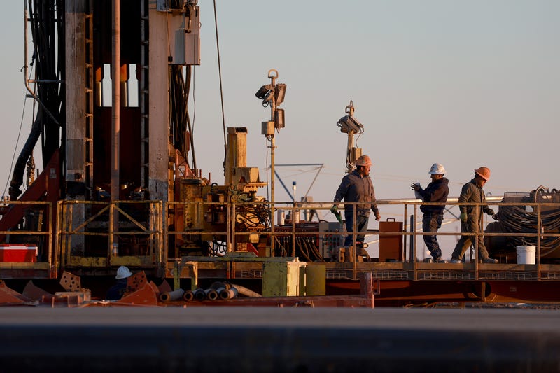 Workers on an oil drilling rig set up in the Permian Basin oil field on March 12, 2022, in Stanton, Texas.