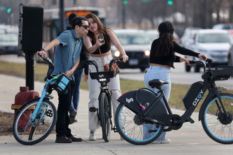 Three people using Divvy bikes