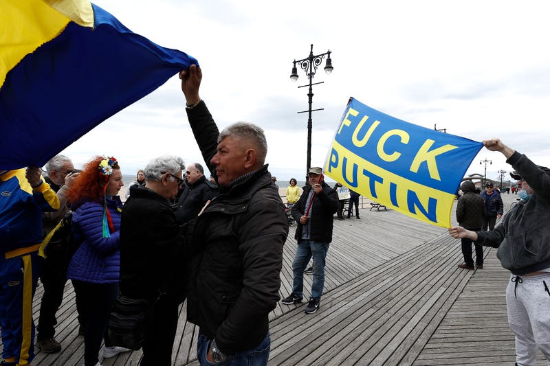 A rally participant holds a Ukrainian flag as others listen to mostly Russian speakers denounce the war in the Ukraine on March 20, 2022 in the Brighton Beach section of the Brooklyn borough of New York City.  