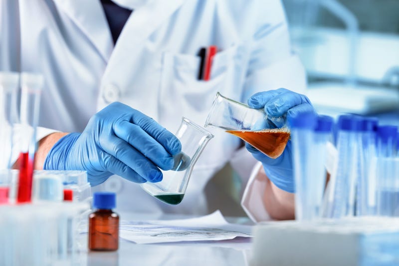 Researcher working with fluids in flasks in a laboratory