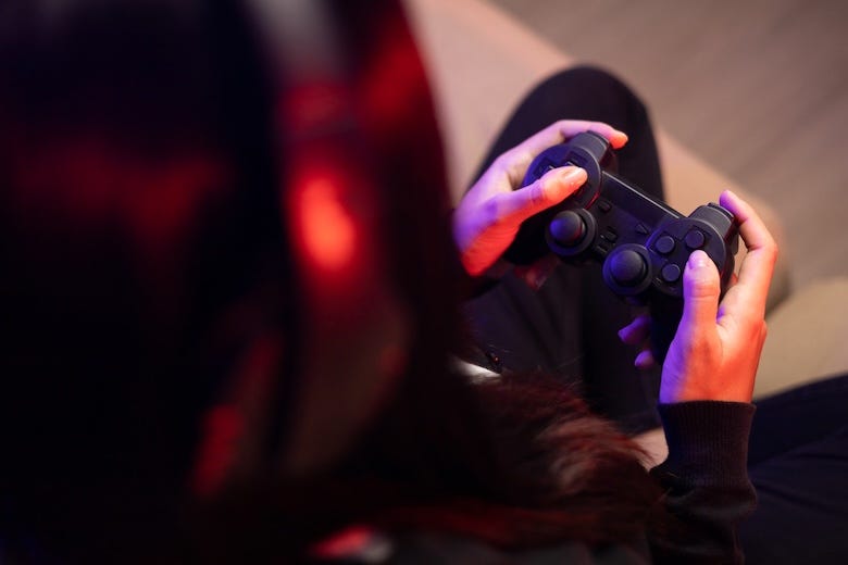 Close up image of woman’s hands holding a video game controller