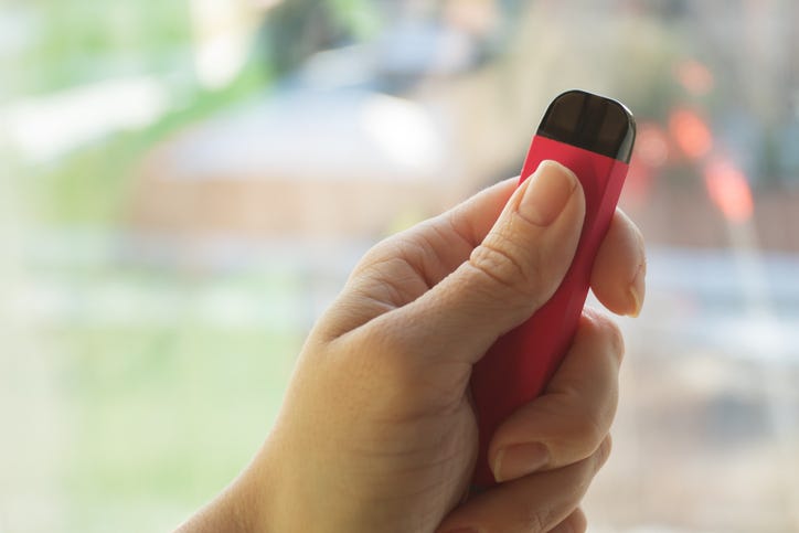 Stock image of a person holding a vape pen.