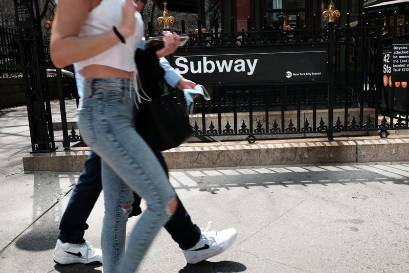 People walk by a subway stop in a busy midtown Manhattan on April 13, 2022 in New York City.