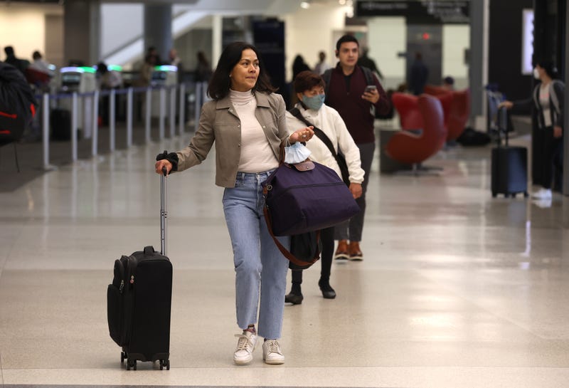 Airline passengers without face masks walk through San Francisco International Airport on April 19, 2022, in San Francisco, California.