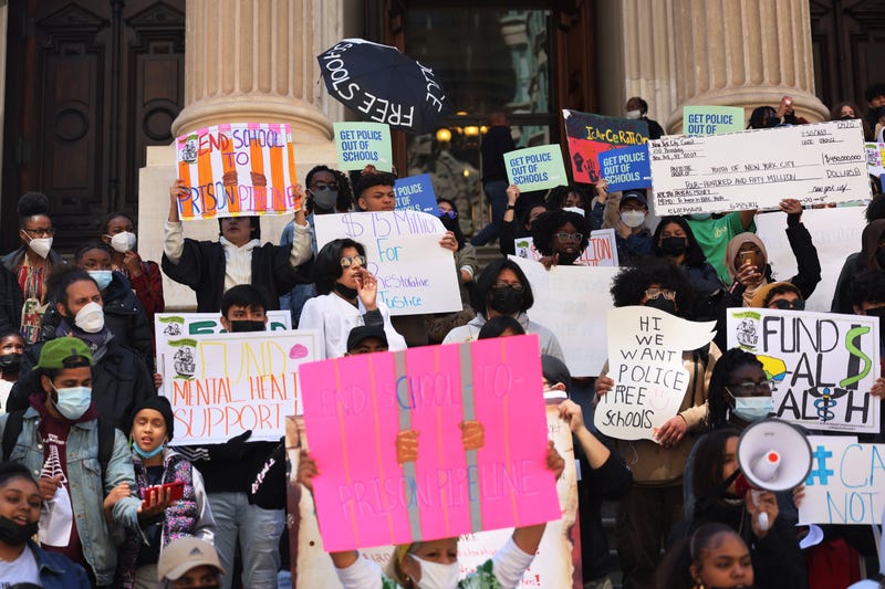 People pause at Tweed Courthouse as they march for police-free school on April 20, 2022 in New York City. Members of the Urban Youth Collaborative, parents, activist and community members gathered for a rally and march calling on City Council to divest from school police and invest in students.