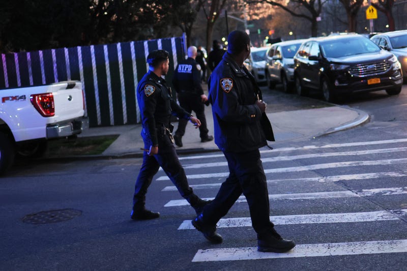 NYPD officers walk back to their patrol cars after an arrest on April 20, 2022 in the Flatbush neighborhood of Brooklyn