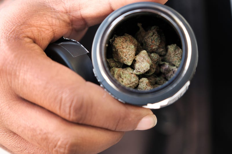 A man shows off a recent marijuana purchase from a dispensary.