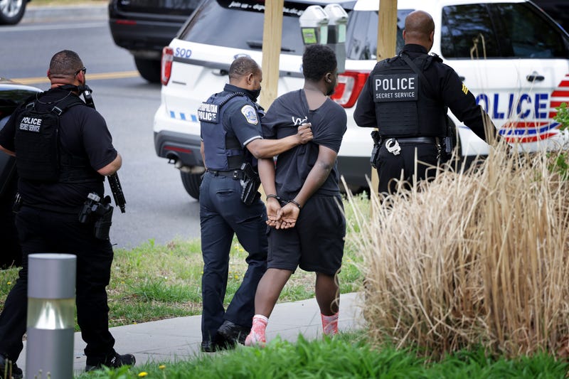 WASHINGTON, DC - APRIL 22: Metropolitan and Secret Service Police lead a man in handcuffs away from a shooting scene in the northwest part of the city on April 22, 2022 in Washington, DC. Police were called to the scene and there are reports of several shooting victims.
