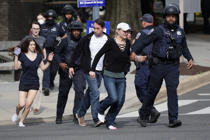 WASHINGTON, DC - APRIL 22: Metropolitan Police run as they escort people, some without shoes, away from a shooting scene in the northwest part of the city on April 22, 2022 in Washington, DC. Police evacuated residents from the shooting scene Friday afternoon and there were reports of several shooting victims.