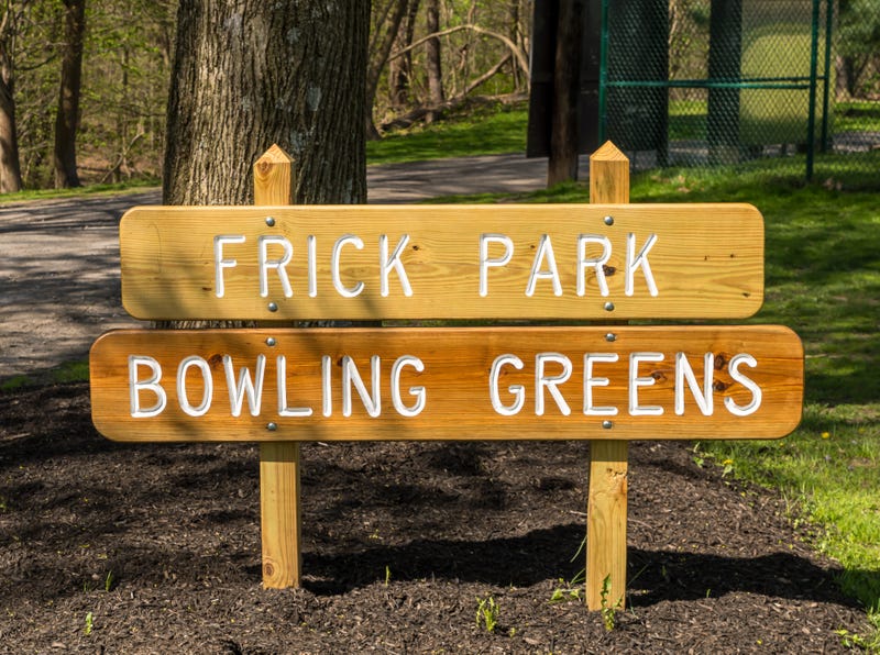 A wooden sign engraved with Frick Park Bowling Greens in Frick park located in Pittsburgh, Pennsylvania