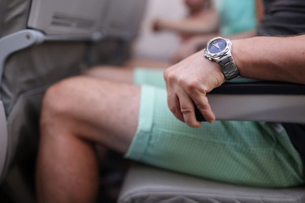 Man resting arm on armrest in plane