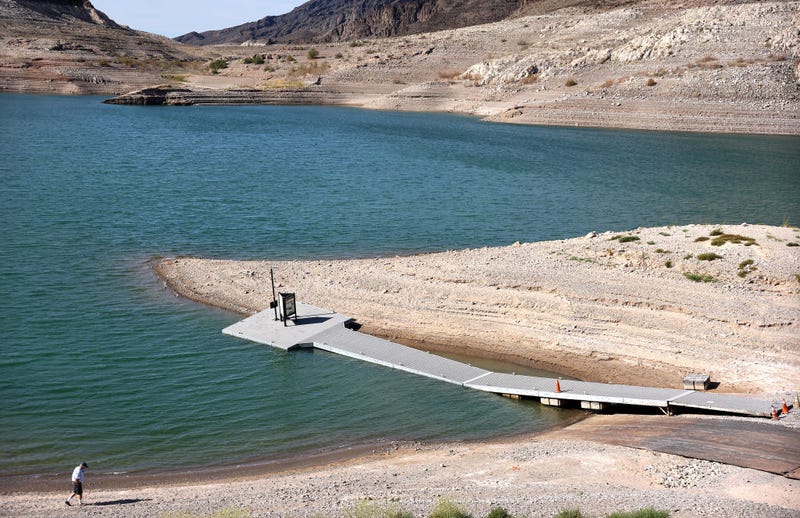 A person walks near a faltering boat launch ramp which is set to be relocated due to lowering water levels on Lake Mead on May 10, 2022 in the Lake Mead National Recreation Area, Nevada.