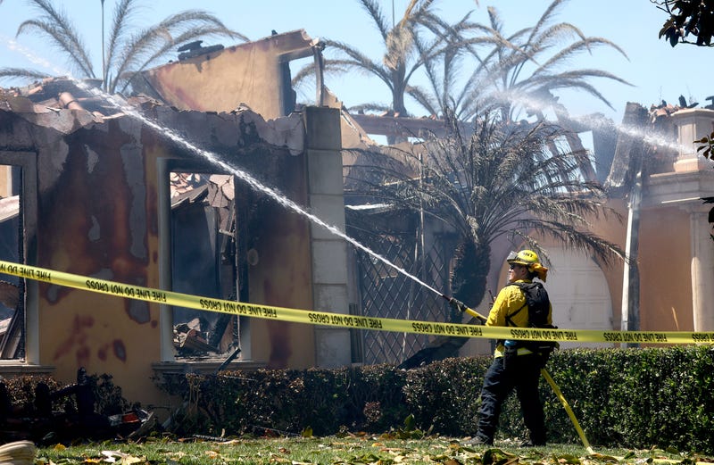 A firefighter works to put out hotspots at one of over 20 homes destroyed by the Coastal fire on May 12, 2022 in Laguna Niguel, California. 