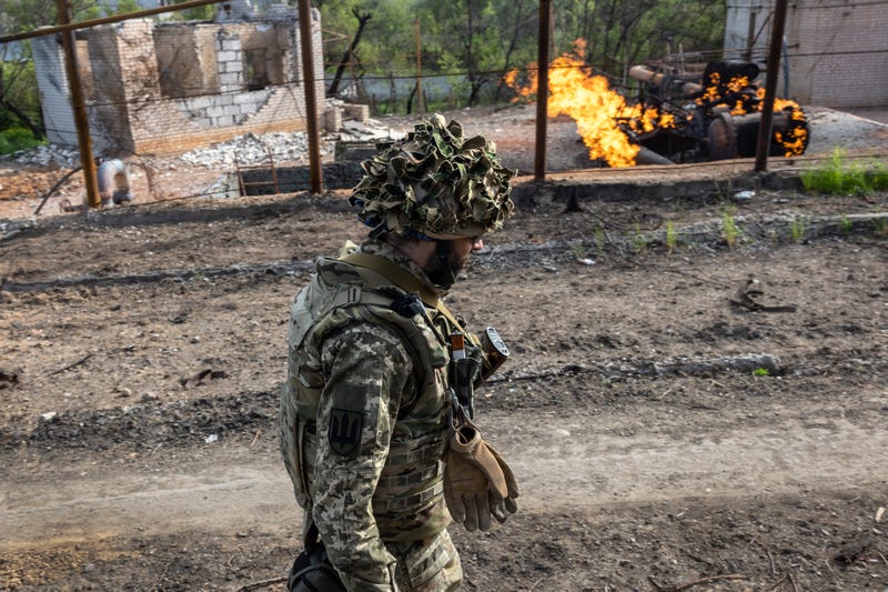 A Ukrainian Army soldier walks past a burning natural gas terminal on May 13, 2022 on the northern outskirts of Kharkiv, Ukraine.