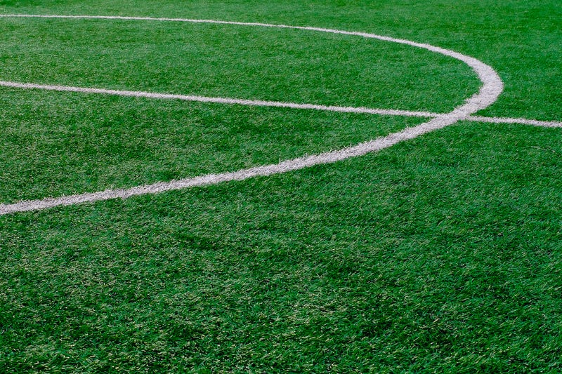 Artificial turf soccer field with center marker line.