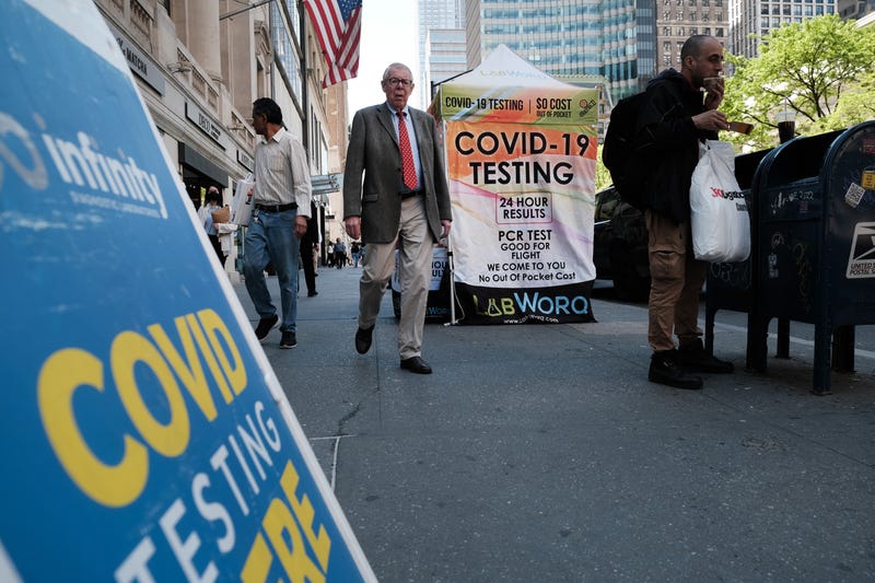 People walk past a COVID testing site on May 17, 2022 in New York City. New York’s health commissioner, Dr. Ashwin Vasan, has moved from a "medium" COVID-19 alert level to a "high" alert level in all the five boroughs following a surge in cases.