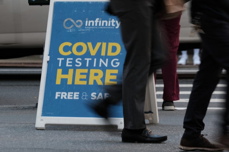 MAY 17: People walk past a Covid testing site on May 17, 2022 in New York City. New York’s health commissioner, Dr. Ashwin Vasan, has moved from a "medium" COVID-19 alert level to a "high" alert level in all the five boroughs following a surge in cases.