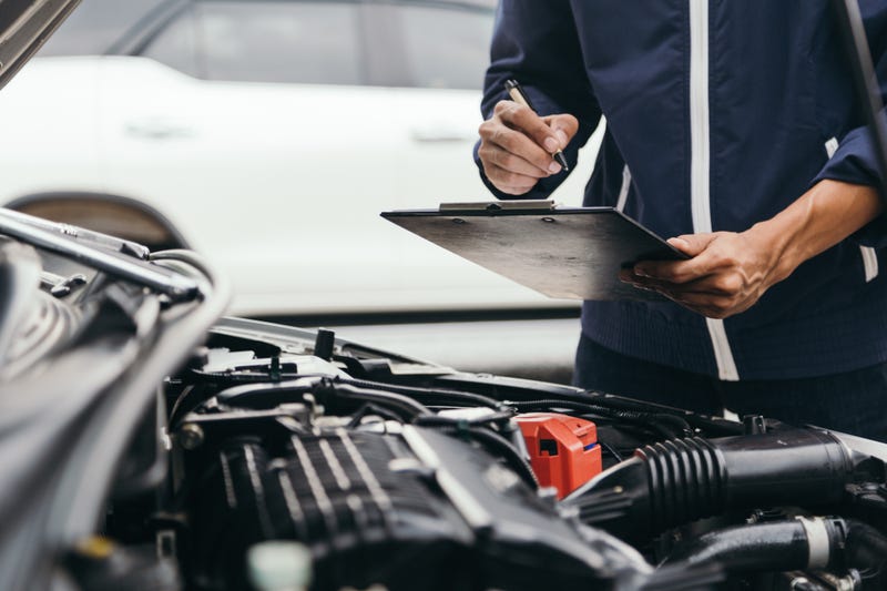 Automobile mechanic repairman hands repairing a car engine automotive workshop